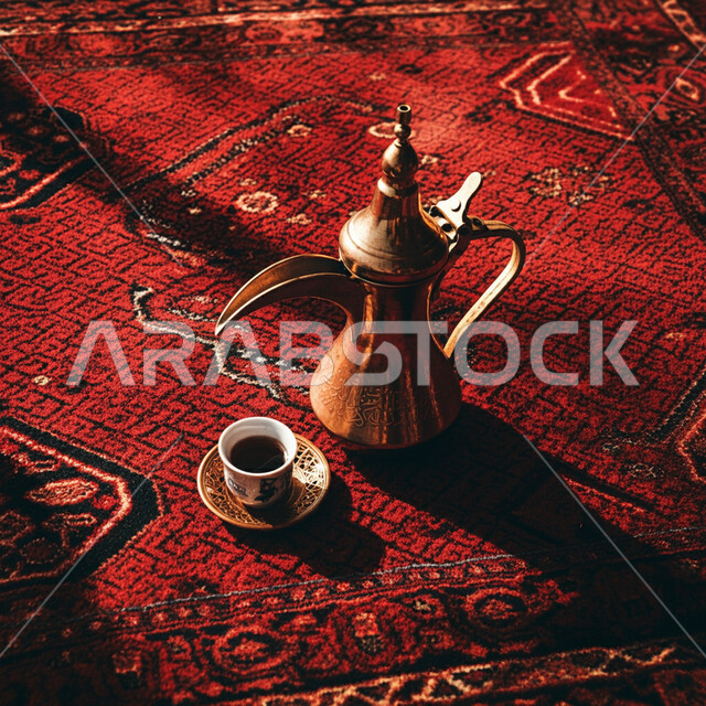 حسن الضيافة والاستقبال, تقديم المشروبات الساخنة في الزيارات, العادات والتقاليد العربية الشرقية, دلة نحاسية وفنجان من القهوة على سجادة تقليدية منقوشة, الجلسات الشعبية في المملكة العربية السعودية