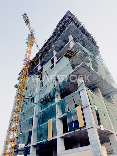 Modern building under construction, concept of structural and architectural engineering, construction works, concrete pouring and foundation laying, implementation of the reconstruction plan and forming the metal structure, urban expansion in the Kingdom of Saudi Arabia