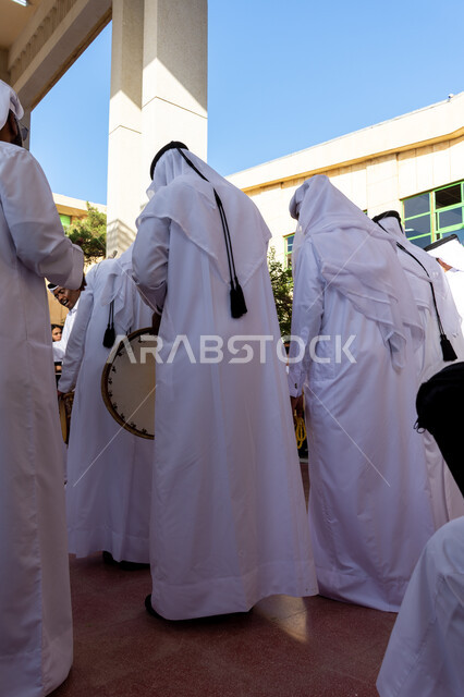 فنون وعروض شعبية، رقصات في المناسبات الوطنية والمهرجانات والأعياد في قطر، فعاليات واحتفالات لللعرضات والفنون, الأحياء التراثية القديمة، فرقة عرضة عربية خليجية سعودية يرتدون الثوب التقليدي والغترة يقومون بالاحتفال وقرع الطبول