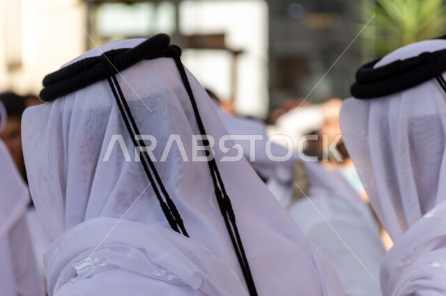 Folk arts and shows, dances on national occasions, festivals and holidays in Qatar, events and celebrations for shows and arts, old heritage neighborhoods, a Saudi Arabian Gulf Ardah band wearing traditional dress and ghutra celebrating and beating drums