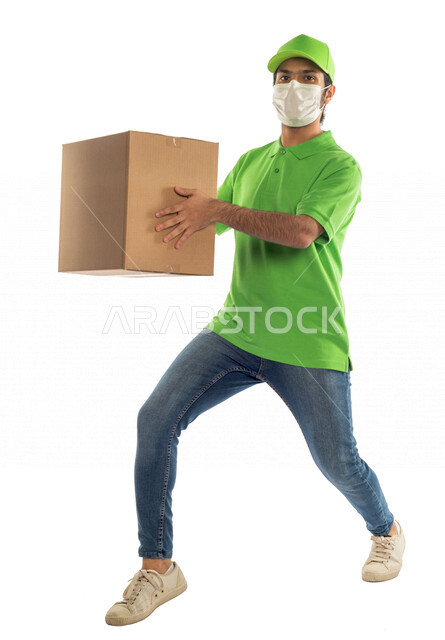 Portrait of a Saudi Arabian Gulf man working in the delivery of orders and goods to customers, online shopping, online orders, smart shopping, reliable shipping and delivery process, delivery representative, adherence to preventive precautions, adherence