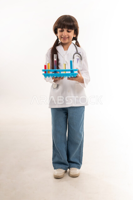 أمنية الحصول على مهنة الباحثة الكيميائية، اجراء تجارب وتفاعلات كيميائيه حيويه، بورتريه لفتاة عربية خليجية عمانية ترتدي المعطف وتحمل انابيب الاختبار، بنت سعودية تقوم بأبحاث علمية في معمل الكيمياء، تحديد المهنة المستقبلية منذ الصغر، الطول الكامل للجسم، خلفية بيضاء
