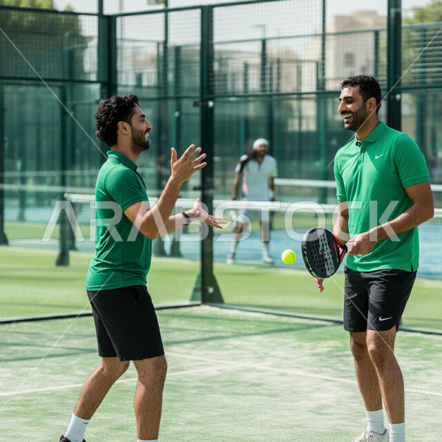 Playing matches and tournaments with challenge and determination, doing tennis exercises, youth sports and recreational activities, young Gulf Arab Saudi players wearing sportswear playing a tennis match, training to master the game of padel, expressions and gestures indicating enthusiasm and integration into the exercise