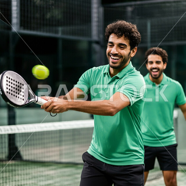 خوض المباريات والبطولات بتحدي وعزيمة، القيام بتمرينات رياضة التنس، رياضات شبابية وأنشطة ترفيهية، لاعبون شبان عربيون خليجيون سعوديون يرتدون ملابس رياضية يلعبون مباراة كرة المضرب، التدرب على إتقان لعبة البادل، تعابير وإيماءات تدل على الحماس والاندماج بالتمرين