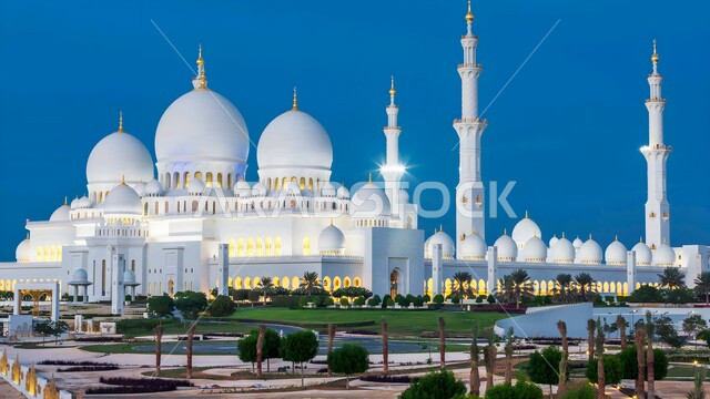 Sheikh Zayed Grand Mosque at night in Abu Dhabi, the architectural art of the domes and minarets of the Islamic style mosques in the United Arab Emirates, the call of Muslims to perform prayers, the interest in afforestation and planting green plants