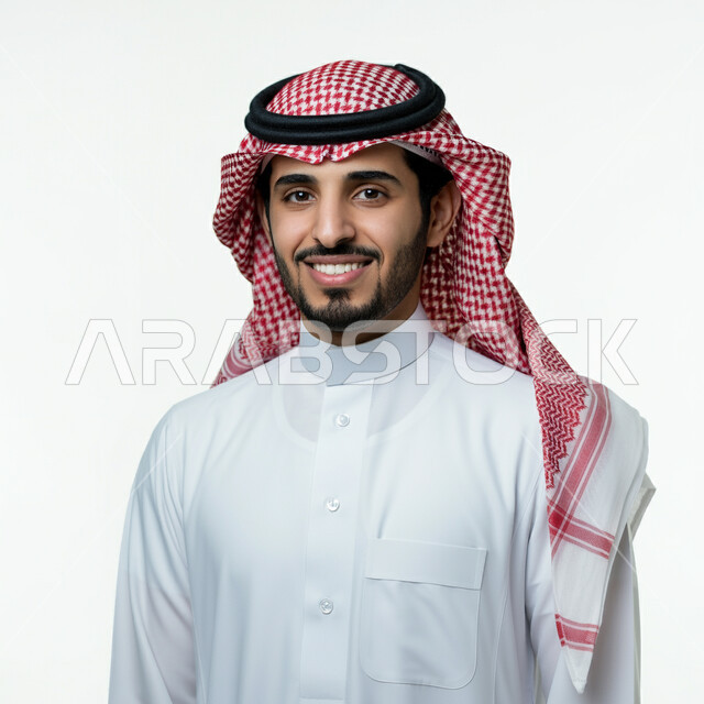 تعابير الثقة بالنفس، مفهوم الأناقة والوسامة، بورتريه مقرب لرجل عربي خليجي سعودي يرتدي الثوب التقليدي والشماغ ينظر إلى الكاميرا بإيماءات البشاشة والسرور، الاهتمام بالمظهر الخارجي، خلفية بيضاء