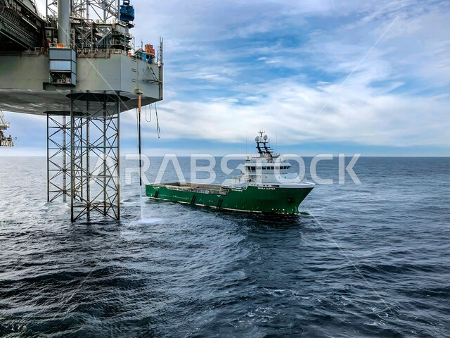 استخراج وتصدير الثروات الباطنية، صورة مقربة لسفينة أمام منصة نفط وسط البحر، جودة الأدوات والمعدات لصناعة وتخزين البترول، آلات حفر ضخمة, استنباط الزيوت والغازات في المملكة العربية السعودية