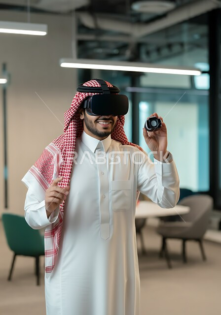 التسلية و المتعة بالمشاهدة عبر نظارة الواقع الافتراضي، التطور التقني والتكنولوجي, صورة مقربة لشاب عربي خليجي سعودي يرتدي الشماغ و الثوب التقليدي ينظر من خلال نظارات ثلاثية الأبعاد (الفي ار) بإيماءات السرور, الاندماج ومحاكاة العالم الخيالي
