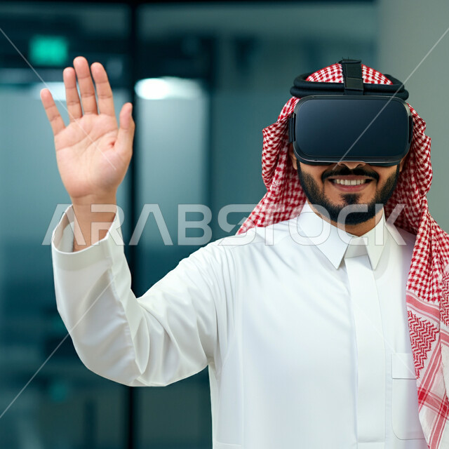 Interaction, integration and simulation of the imaginary world, a smiling Saudi Arabian Gulf man wearing the traditional thobe and shemagh, wearing virtual reality glasses, raising his palms up to try to touch something, gestures of prohibition and stopping doing something, fun and entertainment watching through 3D glasses