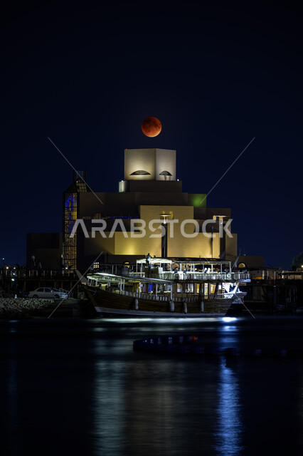 متحف الفن الإسلامي في الكورنيش الدوحة، الواجهات البحرية ليلا، الفن الهندسي المعماري المتطور بتصاميم تعكس احترام الثقافة القطرية وهوية البلاد، المتاحف والمعالم التراثية الحضارية في دولة قطر، السماء خلفية مع البدر المضيء