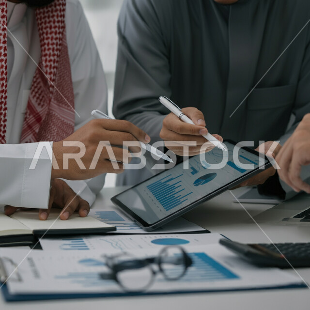 مفهوم الإدارة المتعاونة، جمع بيانات البورصة وسوق الأسهم, بيانات إنجاز وتحقيق أهداف الشركة، صورة مقربة لاجتماع رجال أعمال عربيين سعوديين خليجيين داخل مقر الشركة يستخدمون الجهاز اللوحي، دراسة وتحليل الإحصائيات والرسوم البيانية, دمج الأجهزة والتكنولوجيا بالعمل