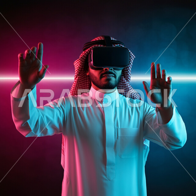 الاندماج ومحاكاة العالم الخيالي، بورتريه لرجل عربي خليجي سعودي يرتدي الثوب التقليدي والشماغ يضع نظارة الواقع الافتراضي يرفع يديه للاعلى بايماءات صد شيء ما والدفاع عن النفس، دمج التسلية بالتقنية والتكنولوجيا، قضاء اوقات ممتعة في عطلة نهاية الاسبوع، خلفية ملونة