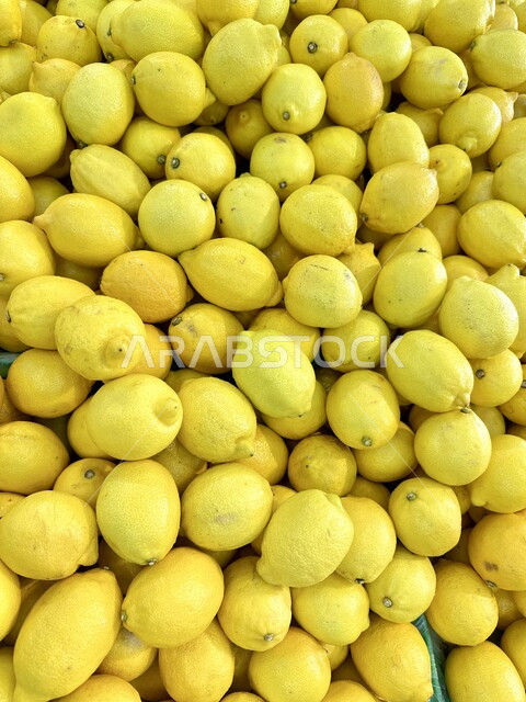 المنتجات والمحاصيل الزراعية الوطنية السعودية، موسم قطاف المحصول الزراعي في المزارع، ثمار صحية ومفيدة, الاهتمام بالزراعة المحلية والاكتفاء الذاتي، صورة مقربة لكومة من الليمون الاصفر الطازج في احدى اسواق الخضار والفواكه في الرياض