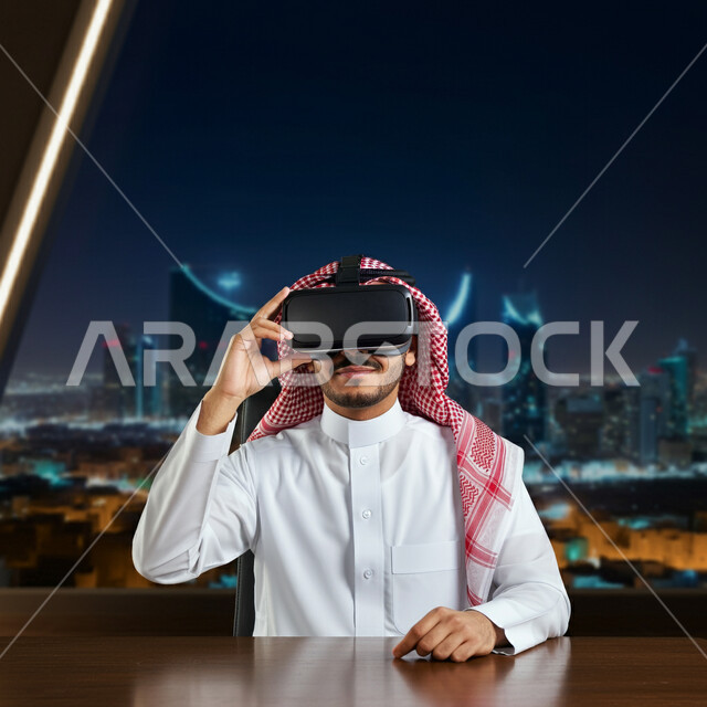 المتعة والتسلية بالمشاهدة عبر نظارة الواقع الافتراضي، رجل عربي خليجي سعودي يرتدي الثوب التقليدي والشماغ يجلس أمام مكتبه يضع نظارات ثلاثية الأبعاد، استخدام التقنية والاجهزة الحديثة، الإندماج ومحاكاة العالم الخيالي، خلفية الابراج وناطحات السحاب