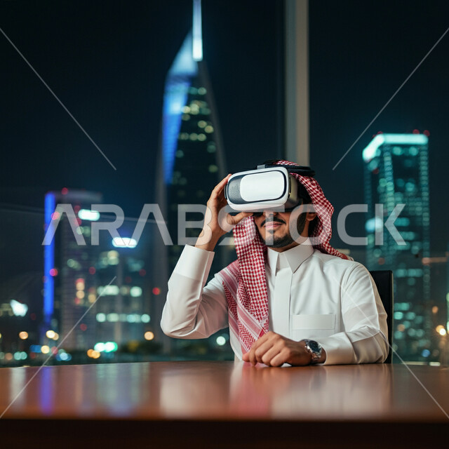 المتعة والتسلية بالمشاهدة عبر نظارة الواقع الافتراضي، رجل عربي خليجي سعودي يرتدي الثوب التقليدي والشماغ يجلس أمام مكتبه يضع نظارات ثلاثية الأبعاد، استخدام التقنية والاجهزة الحديثة، الإندماج ومحاكاة العالم الخيالي، خلفية الابراج وناطحات السحاب