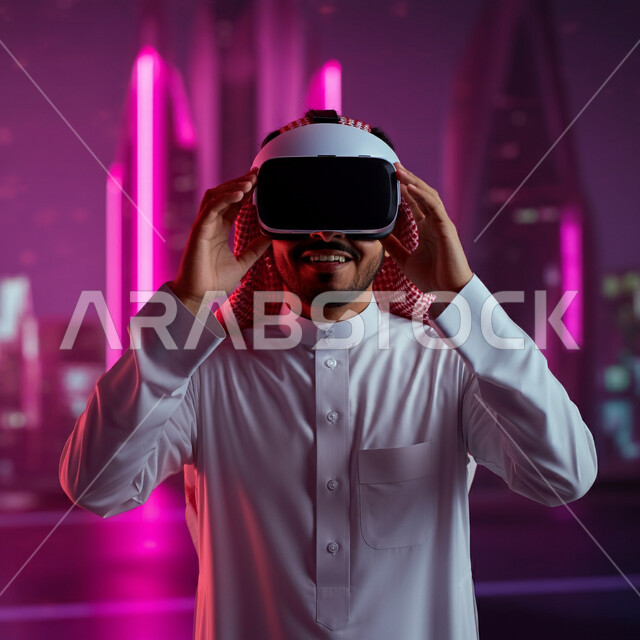 الاندماج والتفاعل ومحاكاة العالم الخيالي، صورة مقربة لرجل عربي خليجي سعودي مبتسم يرتدي الثوب التقليدي والشماغ يضع نظارة الواقع الافتراضي، استخدام التقنية والاجهزة الحديثة، قضاء اوقات ممتعة باستخدام نظارات ثلاثية الابعاد