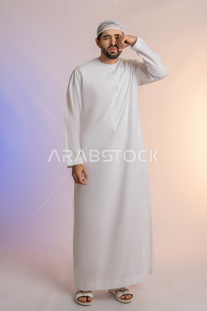 مشاكل التهاب اللثة وتسوس الأسنان, الاشارة إلى الفم بتعابير الإرهاق والتعب, بورتريه لرجل عربي خليجي اماراتي يرتدي الكندورة والقبعة ينظر الى الكاميرة بإيماءات الانزعاج والألم الشديد، خلفية ملونة