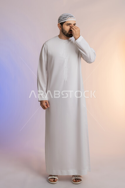 ضعف النظر وتشوش الرؤية، وضع اليد على العين وتغطيها، التهاب واحمرار العيون والحاجة لزيارة الطبيب، التعرض لأذية في الشبكية، بورتريه لرجل عربي خليجي اماراتي يرتدي الكندورة والقبعة يعاني من مشاكل صحية في عينه، خلفية ملونة