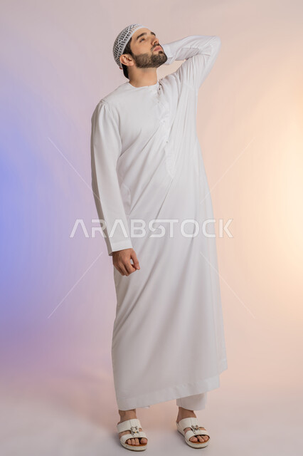 التعرض لنوبات الشقيقة الحادة، آلام الصداع النصفي،  الحاجة لتناول المسكنات وأخذ قسط من الراحة، التعرض للتعب والإرهاق والعمل الطويل، بورتريه لرجل عربي خليجي اماراتي يرتدي الكندورة والقبعة يمسك رأسه بيديه بإيماءات الألم، خلفية ملونة