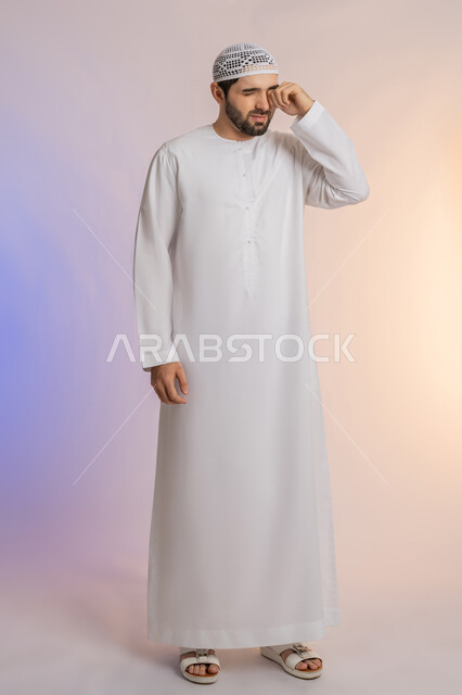 ضعف النظر وتشوش الرؤية، وضع اليد على العين وتغطيها، التهاب واحمرار العيون والحاجة لزيارة الطبيب، التعرض لأذية في الشبكية، بورتريه لرجل عربي خليجي اماراتي يرتدي الكندورة والقبعة يعاني من مشاكل صحية في عينه، خلفية ملونة