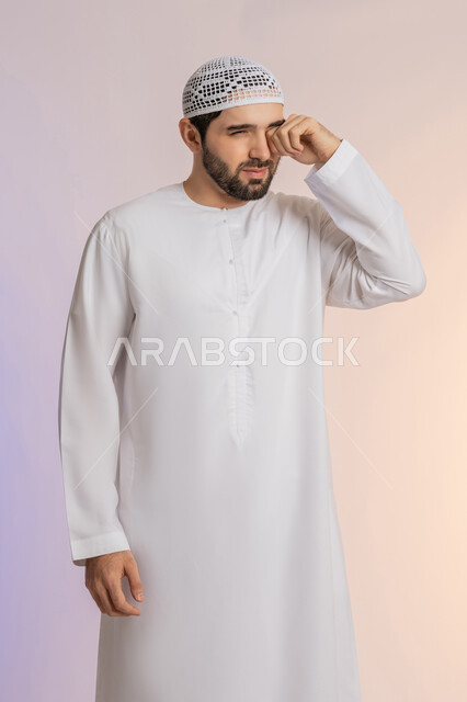 ضعف النظر وتشوش الرؤية، وضع اليد على العين وتغطيها، التهاب واحمرار العيون والحاجة لزيارة الطبيب، التعرض لأذية في الشبكية، بورتريه لرجل عربي خليجي اماراتي يرتدي الكندورة والقبعة يعاني من مشاكل صحية في عينه، خلفية ملونة