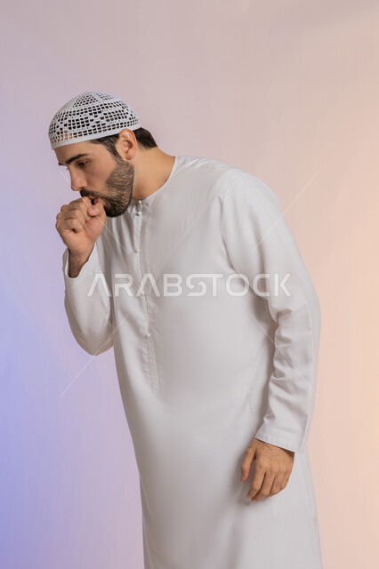 الاحساس بالمرض و الزكام والحاجة الى العلاج والدواء التهاب الصدر التحسسي, بورتريه لشاب عربي خليجي اماراتي يرتدي الكندورة والقبعة يضع يده على فمه بإيماءات السعال, خلفية ملونة