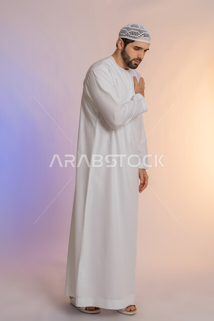 التهاب العضلات والمفاصل، الإحساس بالتعب والإرهاق, إيماءات الألم في الأكتاف، بورتريه لرجل عربي خليجي اماراتي يرتدي الكندورة و القبعة يضع يده على كتفه بتعابير الوجع، الجسم بالطول الكامل، خلفية ملونة