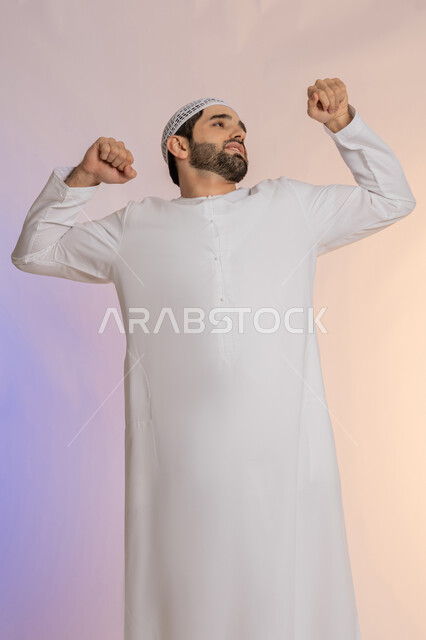 إيماءات التعب والإرهاق، ضرورة أخذ قسط من الراحة والاسترخاء، الشعور بالنعاس والحاجة للنوم، بورتريه لرجل عربي خليجي اماراتي  يرتدي الكندورة والقبعة يقوم بالتثاؤب، الجسم بالطول الكامل, صورة الجسم بالطول الكامل, خلفية ملونة