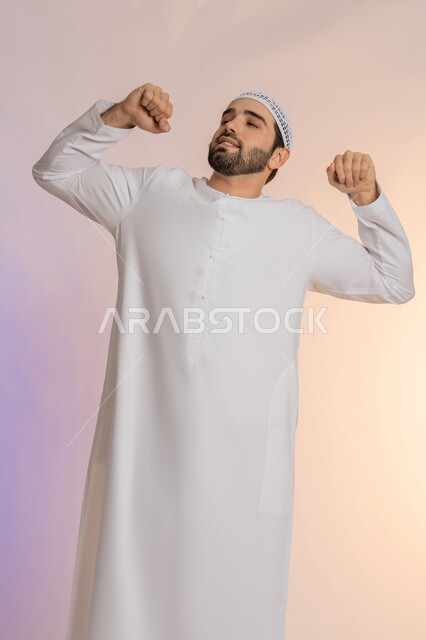 الشعور بالنعاس والحاجة للنوم، ضرورة أخذ قسط من الراحة والاسترخاء، إيماءات التعب والإرهاق، بورتريه لرجل عربي خليجي اماراتي  يرتدي الكندورة والقبعة يقوم بالتثاؤب، خلفية ملونة