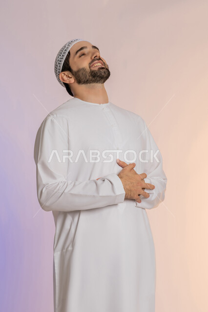 عسر الهضم والشعور بحرقة في المعدة، الحاجة للدواء ووضع خطة علاجية, الإحساس بالمغص و التعب والإرهاق,  بورتريه لرجل عربي خليجي اماراتي يرتدي الكندورة والقبعة البيضاء يمسك بطنه بإيماءات الألم،  طلب المساعده للذهاب الى الطبيب، خلفية ملونة