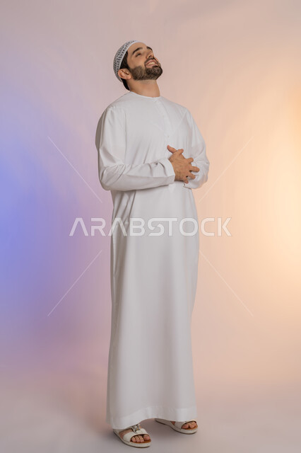 عسر الهضم والشعور بحرقة في المعدة، الحاجة للدواء ووضع خطة علاجية, الإحساس بالمغص و التعب والإرهاق,  بورتريه لرجل عربي خليجي اماراتي يرتدي الكندورة والقبعة البيضاء يمسك بطنه بإيماءات الألم،  طلب المساعده للذهاب الى الطبيب، خلفية ملونة