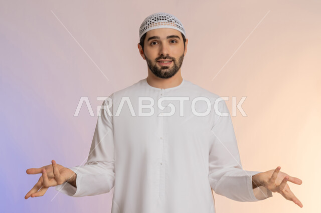 التفاجؤ والاستغراب من شيء ما، الوقوف بإيماءات التعجب والدهشة، الشعور بالسعادة والسرور لسماع الأخبار المنتظرة، بورتريه لرجل عربي خليجي اماراتي يرتدي الكندورة والقبعة يفتح يديه بتعابير الصدمة والذهول والانبهار، خلفية ملونة