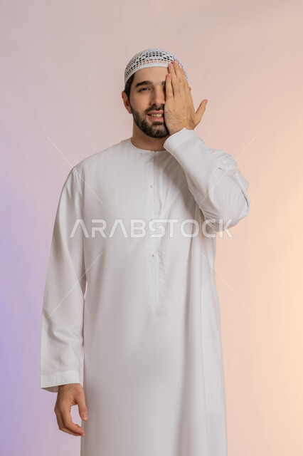 ضعف النظر وتشوش الرؤية، وضع اليد على العين وتغطيها، التهاب واحمرار العيون والحاجة لزيارة الطبيب، التعرض لأذية في الشبكية، بورتريه لرجل عربي خليجي اماراتي يرتدي الكندورة والقبعة يعاني من مشاكل صحية في عينه،خلفية ملونة