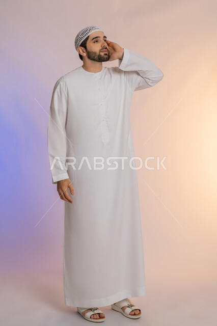 مشاكل التهاب اللثة وتسوس الأسنان, الاشارة إلى الفم بتعابير الإرهاق والتعب, بورتريه لرجل عربي خليجي اماراتي يرتدي الكندورة والقبعة البيضاء يضع يده على فمه بإيماءات الانزعاج والألم الشديد، صورة الجسم بالطول الكامل، خلفية ملونة