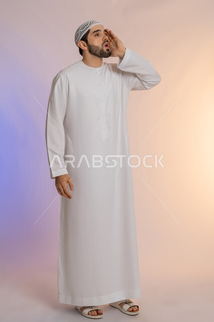 الصراخ والتكلم بنبرة عالية للسماع بشكل جيد، النداء بصوت مرتفع, وضع اليد بجانب الفم لزيادة حدة الأصوات، بورتريه لرجل عربي خليجي اماراتي يرتدي الكندورة والقبعة  ينظر إلى مكان ما بإيماءات الاندماج, الجسم بالطول الكامل، خلفية ملونة