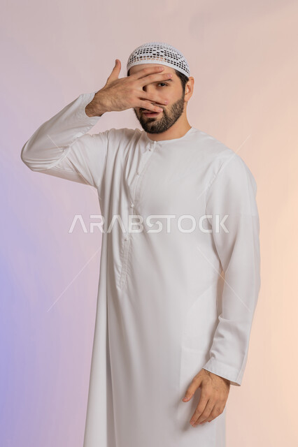 محاولة استراق النظر، الشعور بالخجل والإحراج،  البكاء ومشاعر الحزن، إغماض العينين وعدم الرغبة بالرؤية، التعرض لصدمة وعدم التصديق، بورتريه لرجل عربي خليجي اماراتي يرتدي الكندورة والقبعة يغطي وجهه بيده، خلفية ملونة