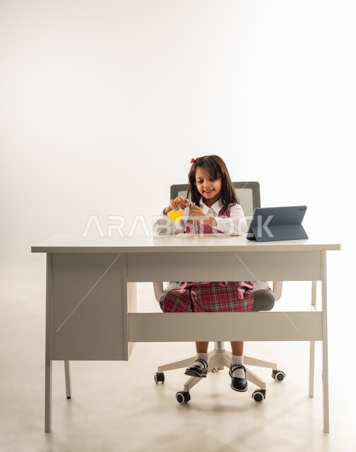 اختيار وتحديد المهنة المستقبلية منذ الصغر، اجراء تجارب وتفاعلات كيميائيه حيويه في المختبر، استخدام التقنيات الحديثة المتطورة ,بورتريه لفتاة عربية خليجية عمانية ترتدي المدرسي تستخدم انابيب الاختبار، تلميذة سعودية تقوم بأبحاث علمية بتعابير السرور، خلفية بيضاء