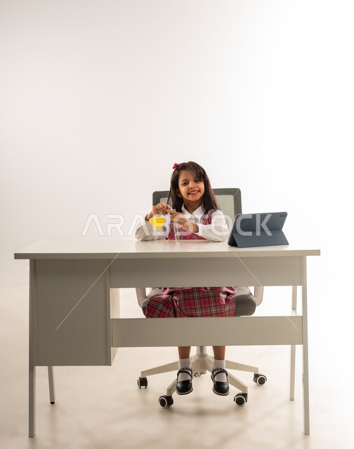 Conducting experiments and biochemical reactions in the laboratory, using modern advanced technologies, choosing and determining the future profession from a young age, portrait of an Arab Gulf Omani girl wearing school uniform using test tubes, a Saudi student conducting scientific research with expressions of pleasure, white background
