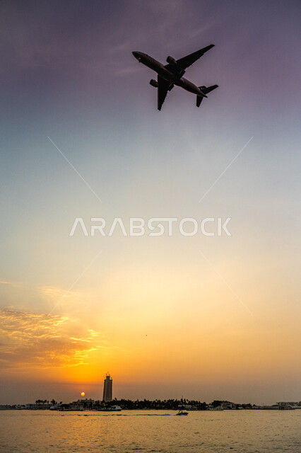 A plane flying in the sky of Jeddah coast at sunset, means of transportation and air transport, the concept of tourism and travel, tourist trips in the Kingdom of Saudi Arabia, transporting departing and arriving passengers to all parts of the world