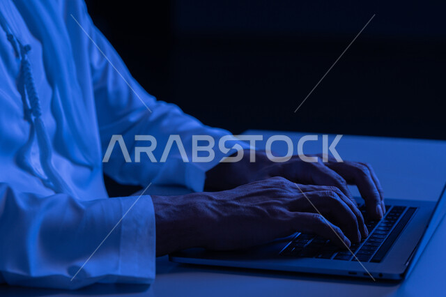 امتلاك مهارة الكتابة السريعة على الكيبورد، صورة مقربة لأيدي رجل عربي خليجي إماراتي يرتدي الكندورة يقوم بالعمل على الحاسب المحمول، مهام ووظائف إدارية مكتبية، إدخال البيانات والكتابة من خلال لوحة المفاتيح، دمج العمل مع التقنية والتكنولوجيا