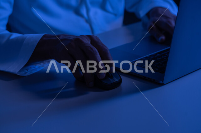 امتلاك مهارة الكتابة السريعة على الكيبورد، صورة مقربة لأيدي رجل عربي خليجي إماراتي يرتدي الكندورة يقوم بالعمل على الحاسب المحمول، مهام ووظائف إدارية مكتبية، إدخال البيانات والكتابة من خلال لوحة المفاتيح، دمج العمل مع التقنية والتكنولوجيا