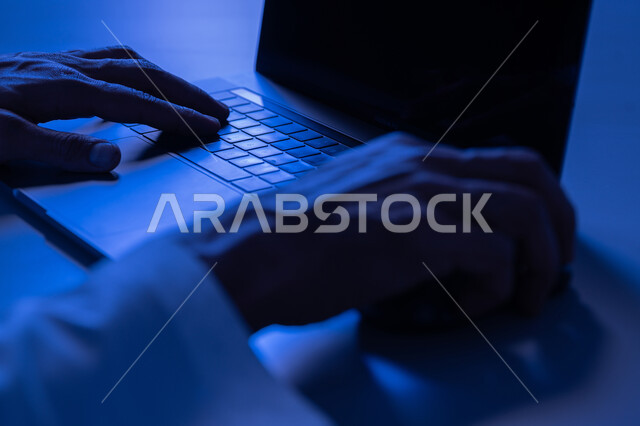 Data entry and typing through the keyboard, integrating work with technology and technology, a young Saudi man with the skill of fast typing on the keyboard, a close-up image of the hands of an Arab Gulf Emirati man working on a laptop, administrative office job tasks