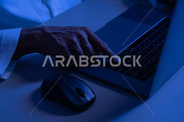 إدخال البيانات والكتابة من خلال لوحة المفاتيح، دمج العمل مع التقنية والتكنولوجيا، شاب سعودي يمتلك مهارة الكتابة السريعة على الكيبورد، صورة مقربة لأيدي رجل عربي خليجي إماراتي يقوم بالعمل على الحاسب المحمول، مهام وظائف إدارية مكتبية