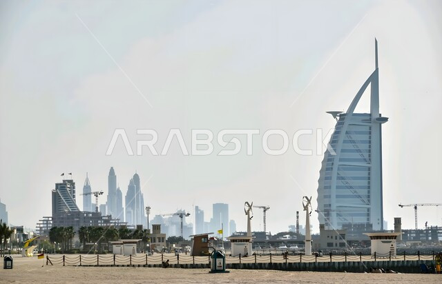جذب واستقطاب السياح من أنحاء العالم, برج العرب في مدينة دبي في وقت النهار, الفن الهندسي المعماري لبناء الأبراج وناطحات السحاب, المباني والمنشآت الشاهقة, الأماكن السياحية الساحلية المشهورة في الإمارات العربية المتحدة