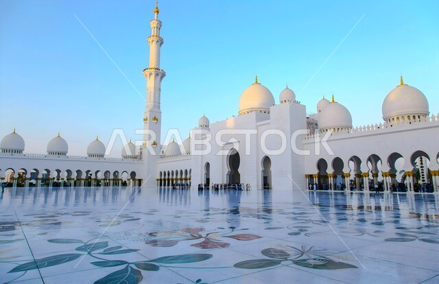 الفن الهندسي المعماري على الطراز العربي الاسلامي للساحة الخارجية للجامع، الأماكن الإسلامية المقدسة، المعالم المشهورة في مدينة ابو ظبي، مسجد الشيخ زايد الكبير في الامارات العربية المتحدة، التصاميم الهندسية المميزة للقبب والمآذن والأعمدة باللون الأبيض