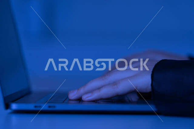 دمج التكنولوجيا الحديثة بالحياة العملية، مهن ووظائف إدارية مكتبية، النقر على لوحة المفاتيح، صناعة المحتويات النصية، مفهوم ادخال البيانات، صورة مقربة من الجانب لايدي امرأة عربية خليجية اماراتية تستخدم الحاسوب المحمول، شابة سعودية تقوم بالكتابة على جهازاللابتوب