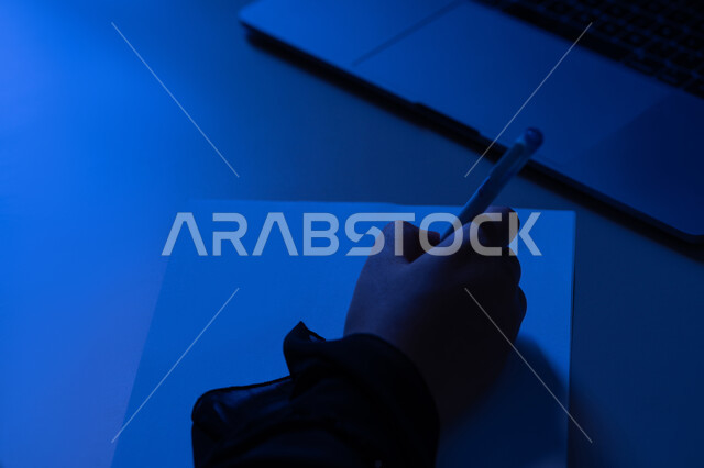 إدارة الأعمال وتنظيمها، استخدام الاوراق البيضاء الفارغة في العمل، شابة سعودية تقوم بتدوين وتسجيل الملاحظات والمعلومات على الورق, صورة مقربة ليد امرأة عربية خليجية اماراتية تقوم بكتابة المهام والأهداف اليومية