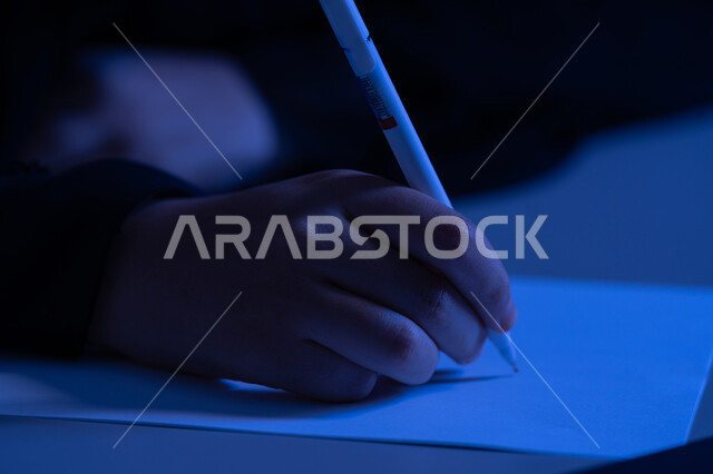 استخدام الاوراق البيضاء الفارغة في العمل، إدارة الأعمال وتنظيمها، شابة سعودية تقوم بتدوين وتسجيل الملاحظات والمعلومات على الورق, صورة مقربة ليد امرأة عربية خليجية اماراتية تقوم بكتابة المهام والأهداف اليومية