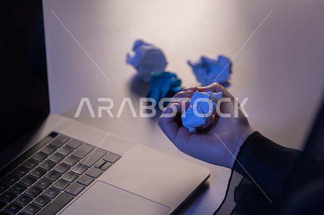 الفشل في تنظيم العمل، صورة مقربة ليد امرأة عربية خليجية اماراتية ترتدي العباءة تحمل ورقة مجعدة، شابة سعودية تبحث عن الافكار والخطط، مفهوم الاخفاق في الكتابة، محاولة ايجاد حلول، مهن ووظائف ادارية مكتبية