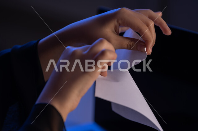 مهن ووظائف إدارية مكتبية، كسر القواعد المهنية في الشركات، عدم الموافقة على شيء ما، صورة مقربة من الجانب لايدي امراة عربية خليجية اماراتية تقوم بتمزيق ورقة بيضاء فارغة، شابة سعودية تعقد صفقة غير ناجحة